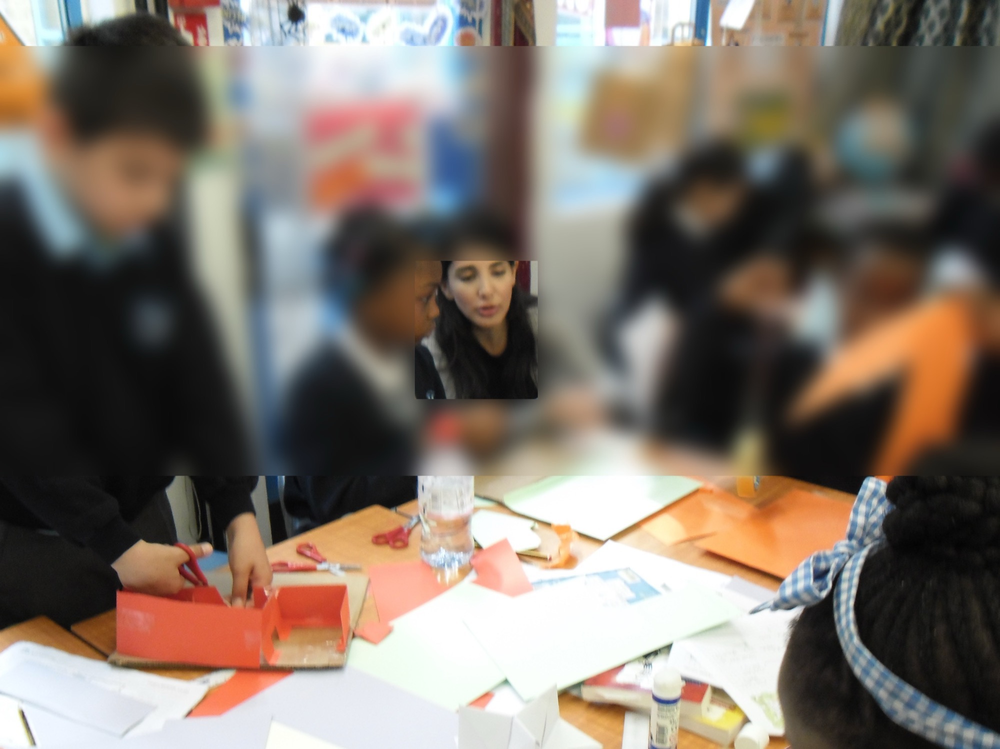 Working with primary school children on a craft-based architecture activity, faces blurred for privacy