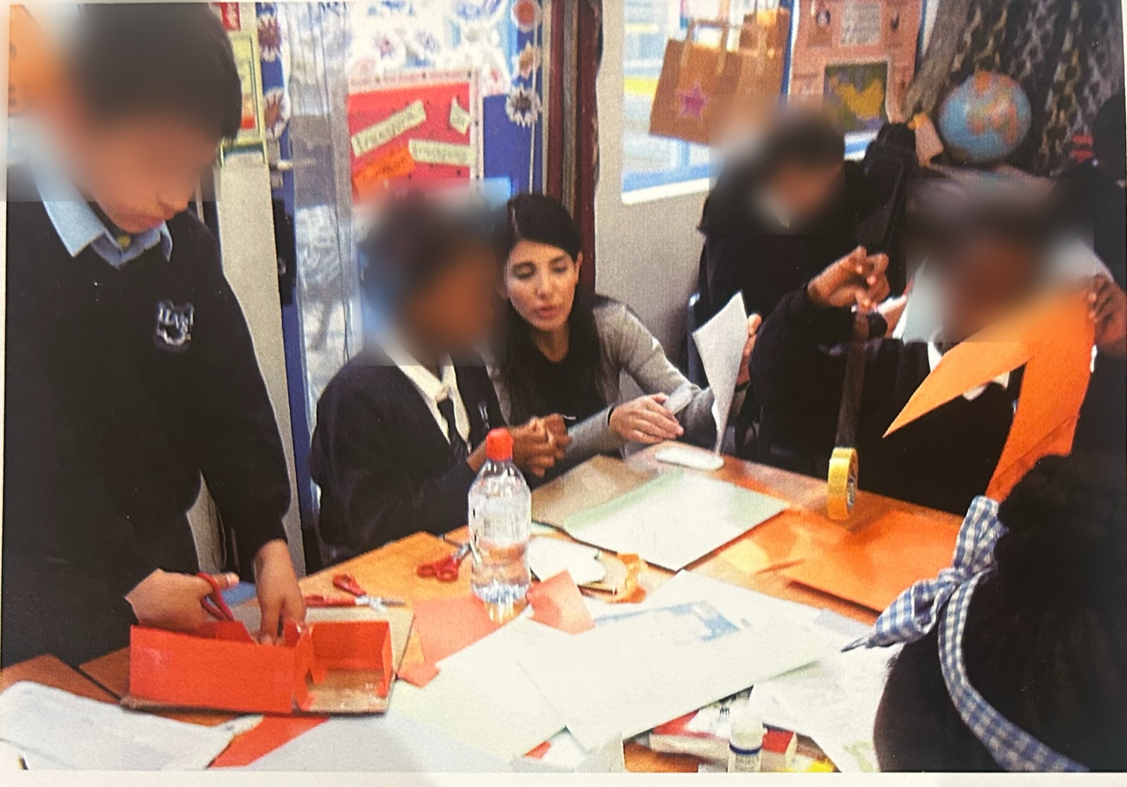 Working with primary school children on a craft-based architecture activity, faces blurred for privacy